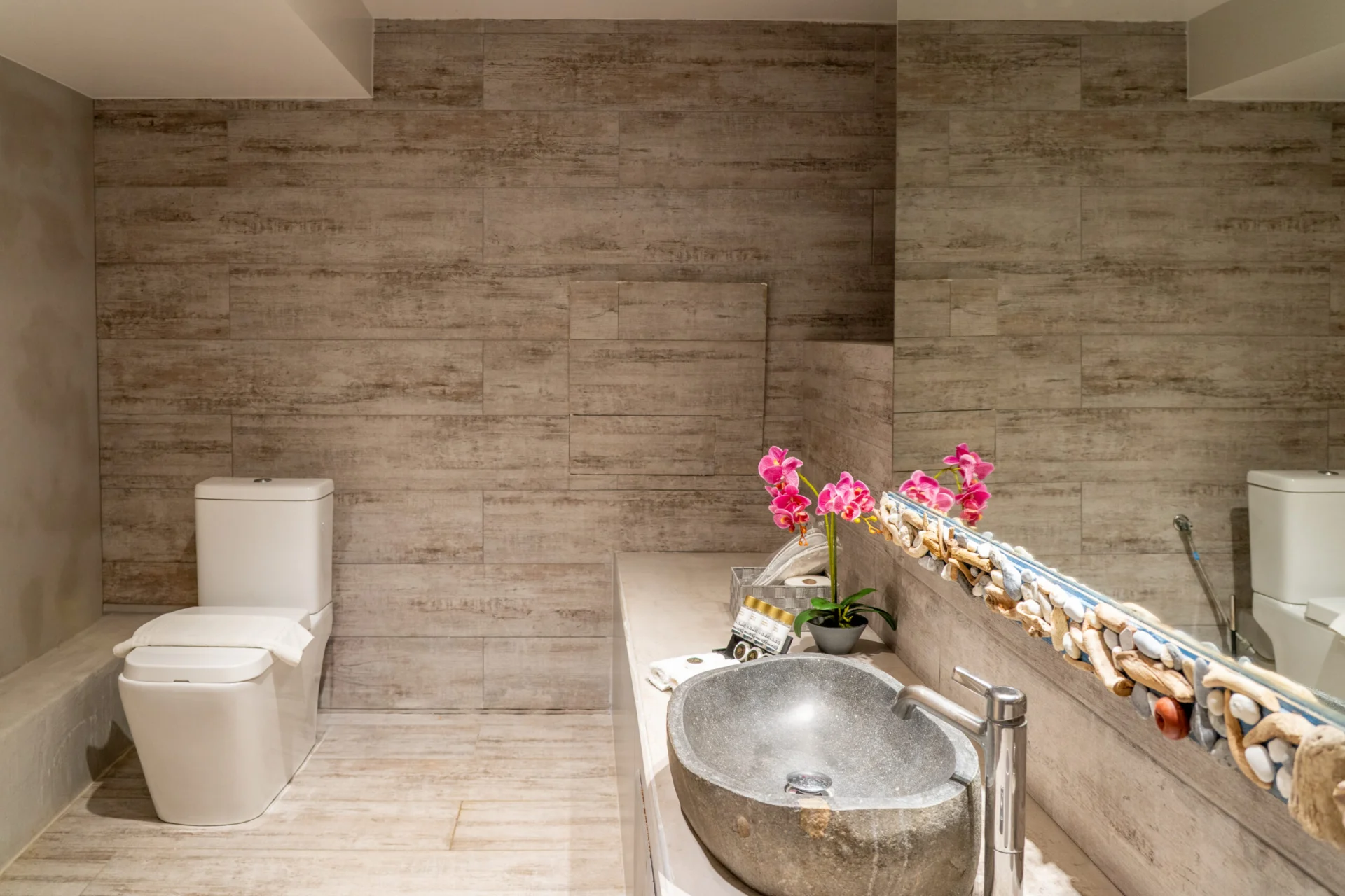 Un lavabo in pietra decorato con orchidee nel bagno della Alessia Family Suite di CORE Luxury Suites, Skiathos.