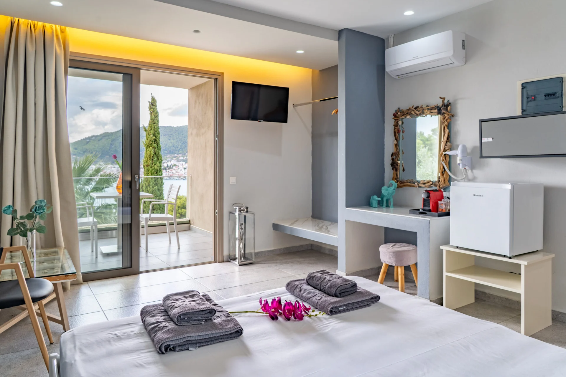 Una scrivania in camera e uno specchio dorato accanto alla porta della terrace nella Alex 1 Classic Suite di CORE Luxury Suites, Skiathos.