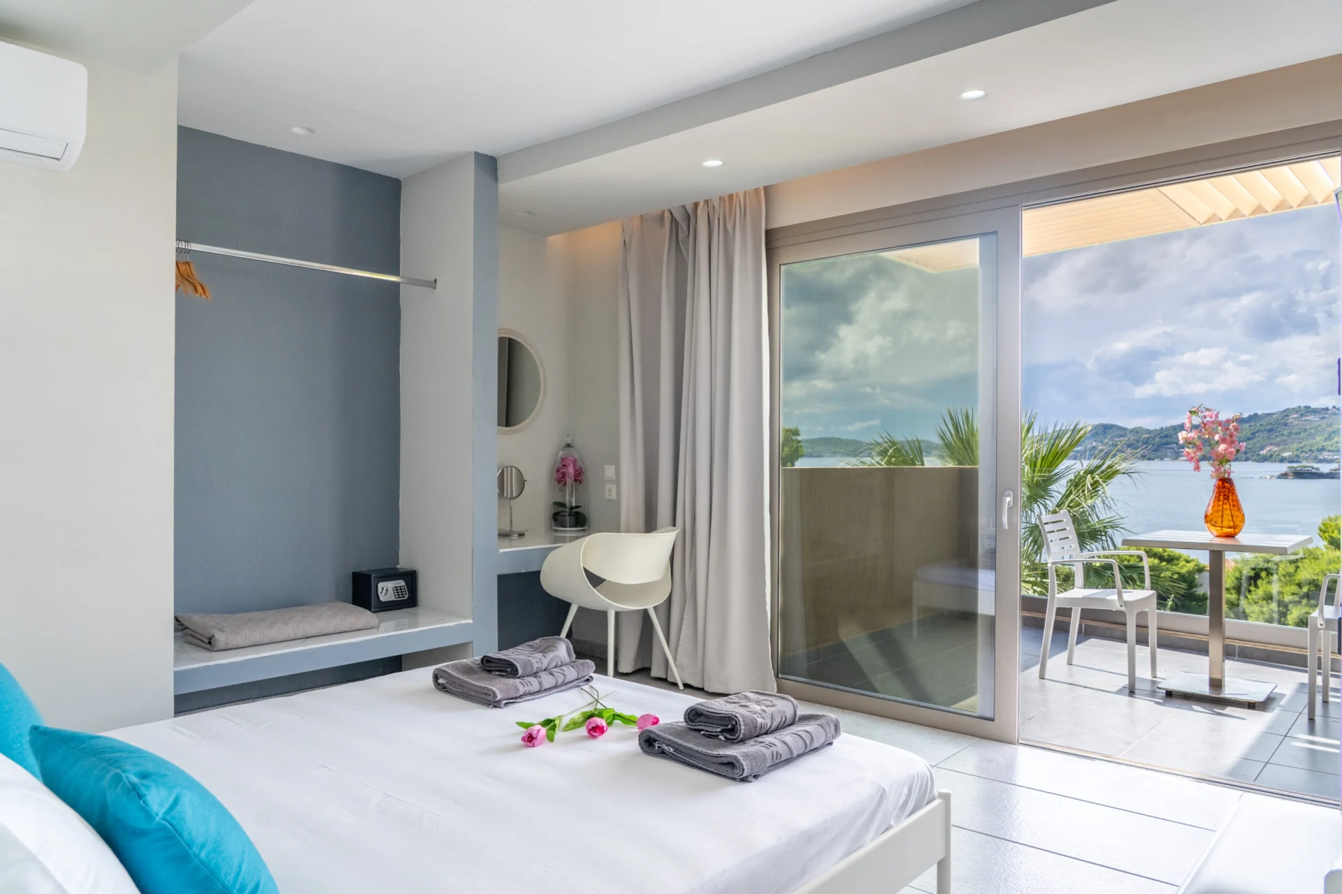Ein Schlafzimmer mit geöffneten Türen zur terrace und Blick aufs Meer in der Alex 2 Deluxe Suite bei CORE Luxury Suites, Skiathos.