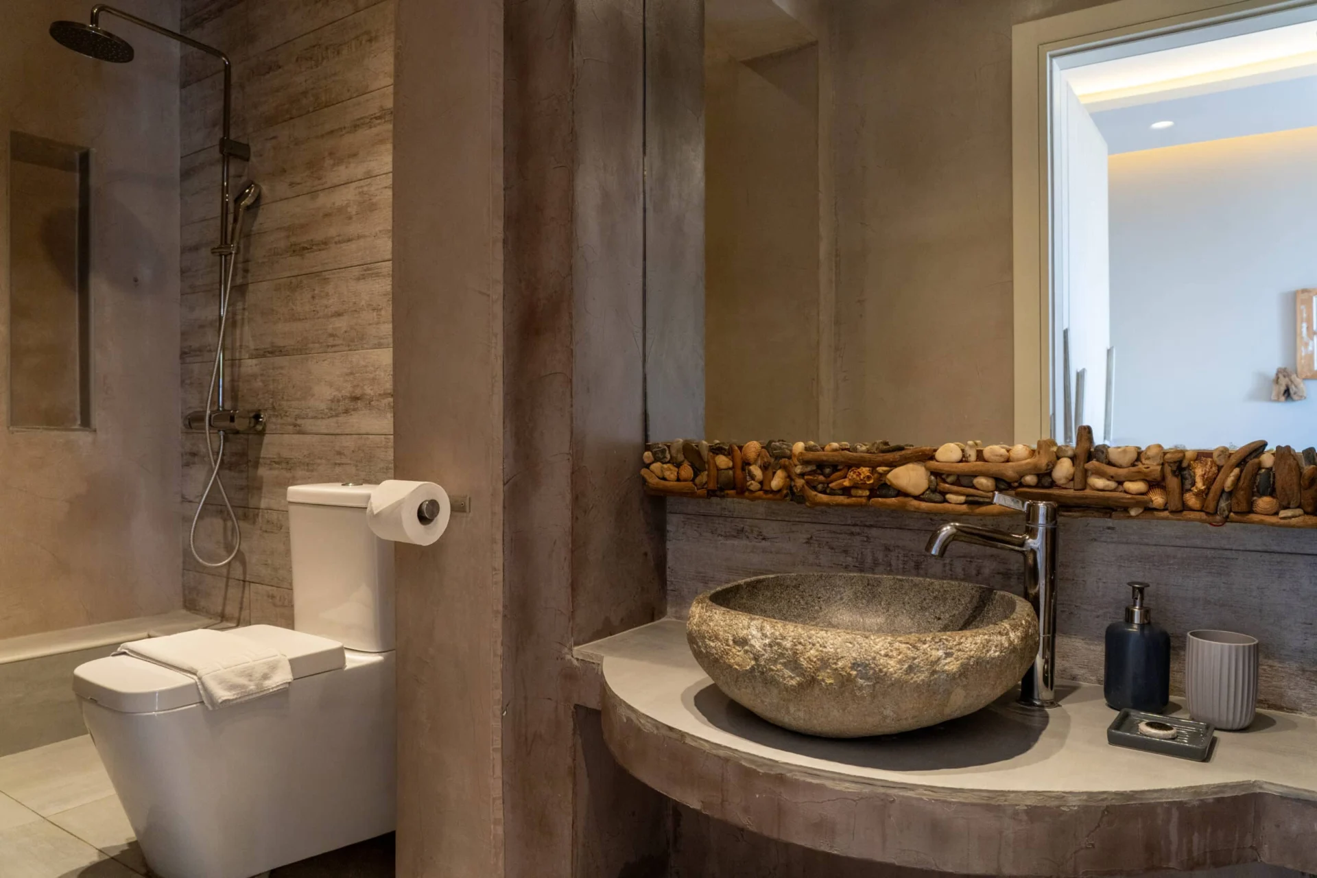 A carved stone basin with driftwood detail in the bathroom in the Demi Classic Suite at CORE Luxury Suites, Skiathos.
