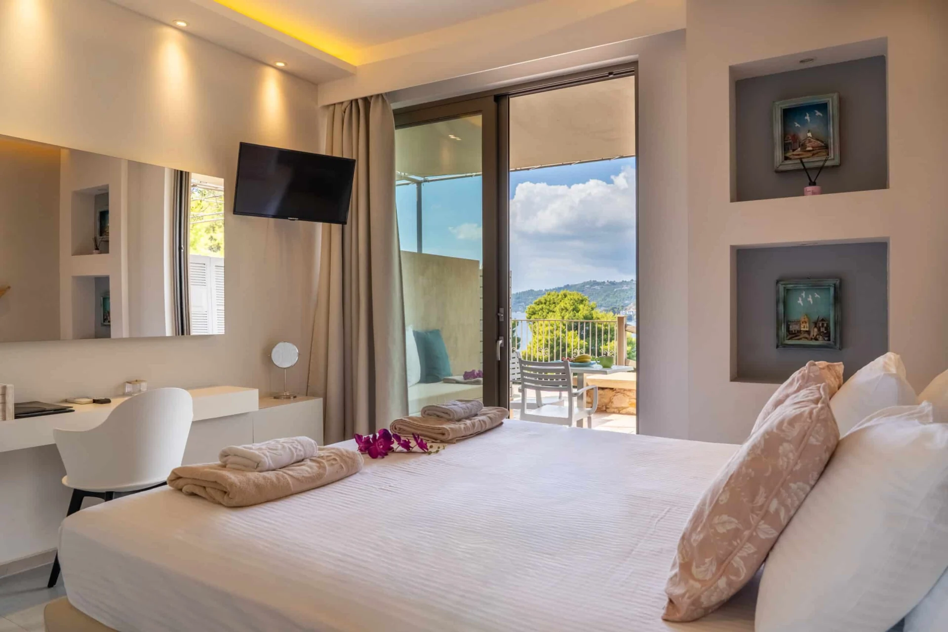A bedroom with the television and the doors to the terrace in the Demi Classic Suite at CORE Luxury Suites, Skiathos.