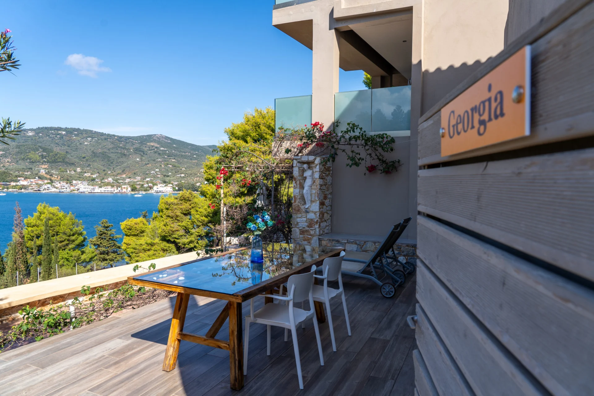 La targhetta intagliata con il nome della suite sulla terrace, con la baia sullo sfondo, nella Georgia Superior Suite di CORE Luxury Suites, Skiathos.