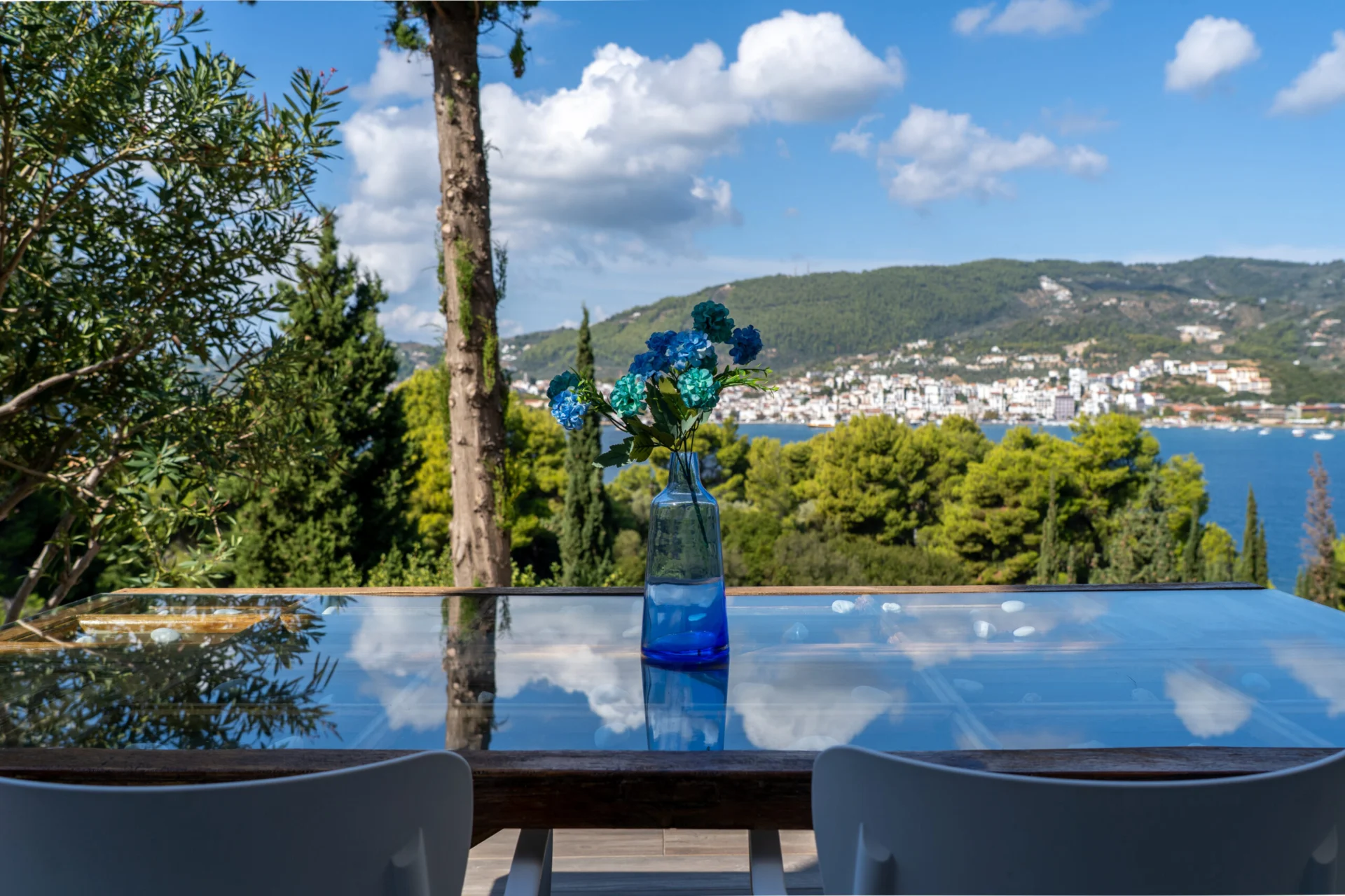A glass terrace table framed by pines above the sea in the Georgia Superior Suite at CORE Luxury Suites, Skiathos.