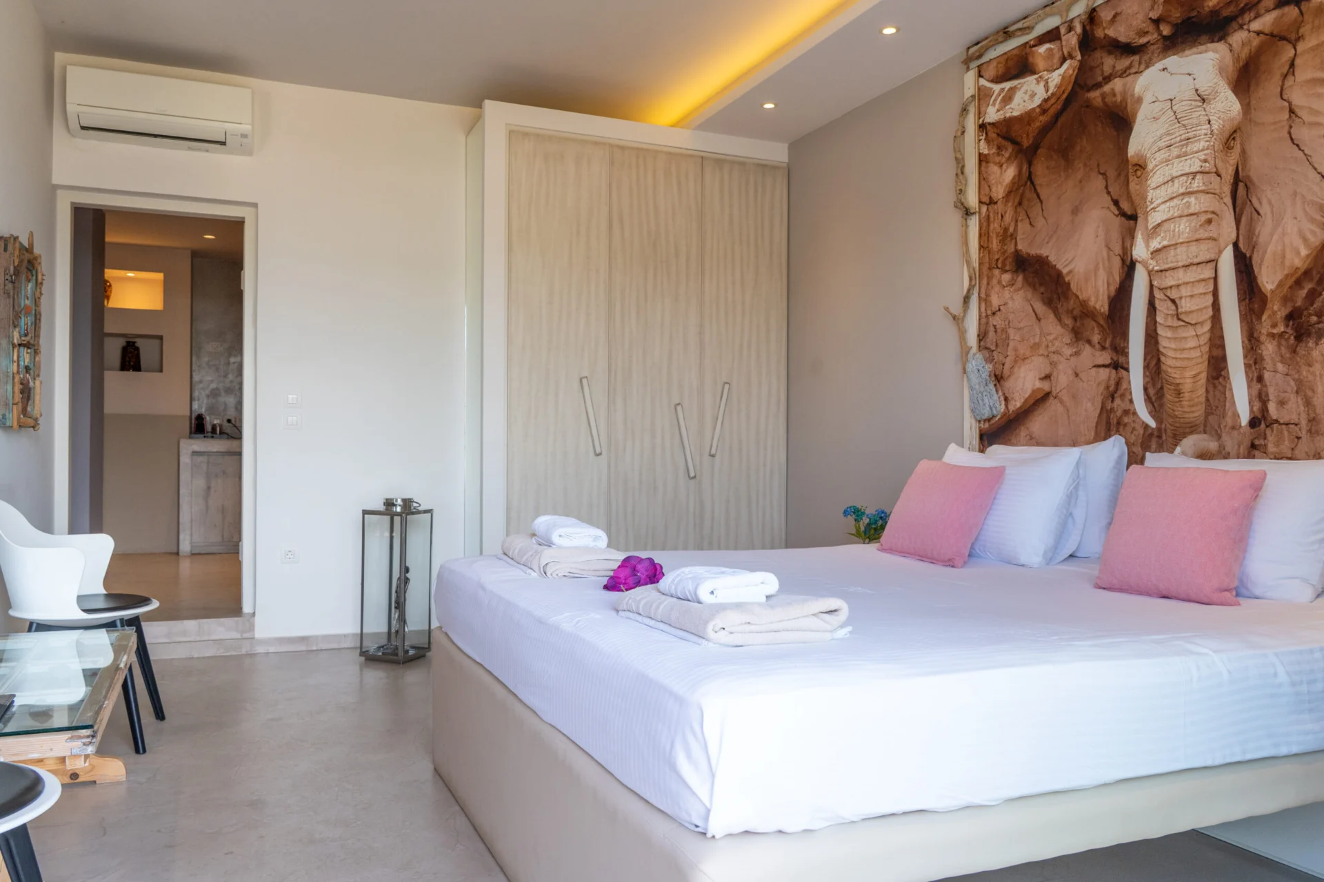 A bed set beneath a large elephant artwork in the Maggi Superior Suite at CORE Luxury Suites, Skiathos.
