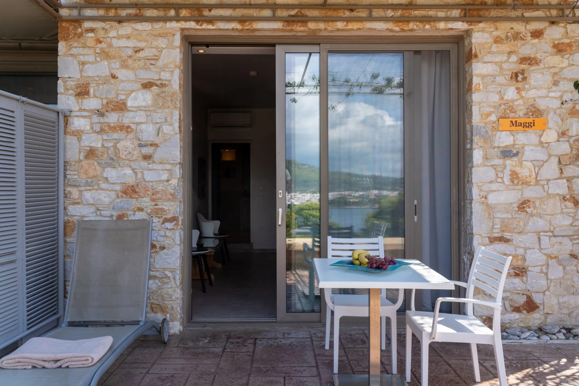 The stone terrace entrance with the suite's carved name plaque in the Maggi Superior Suite at CORE Luxury Suites, Skiathos.