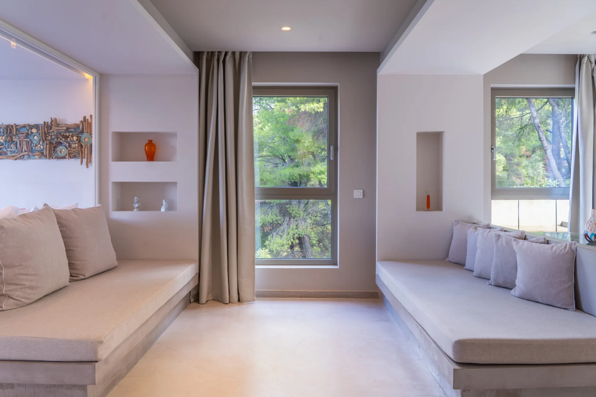 A built-in seating alcove with cushioned daybeds in the Patrick Family Suite at CORE Luxury Suites, Skiathos.