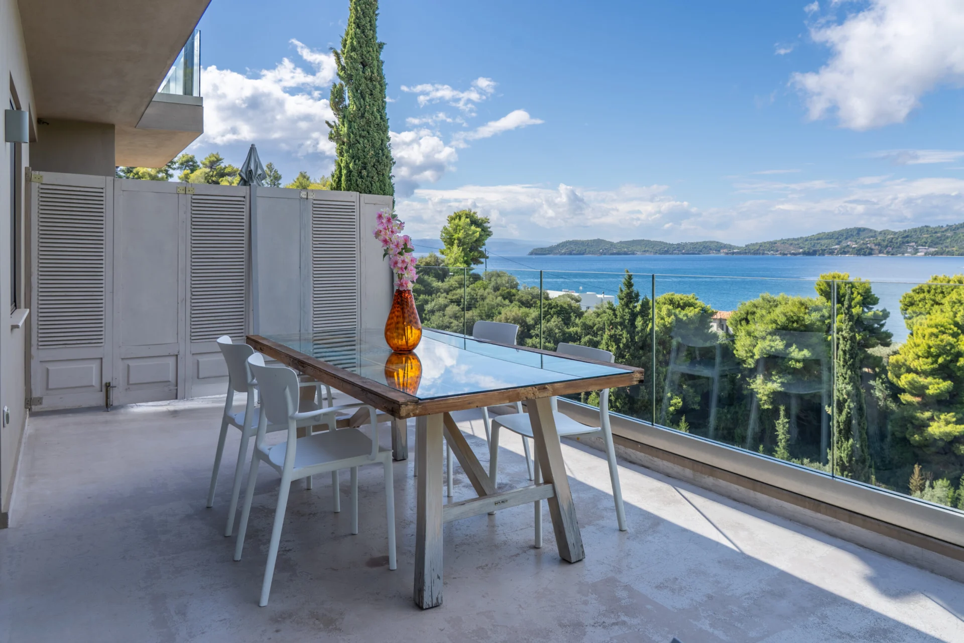 A terrace dining table set above the bay in the Patrick Family Suite at CORE Luxury Suites, Skiathos.