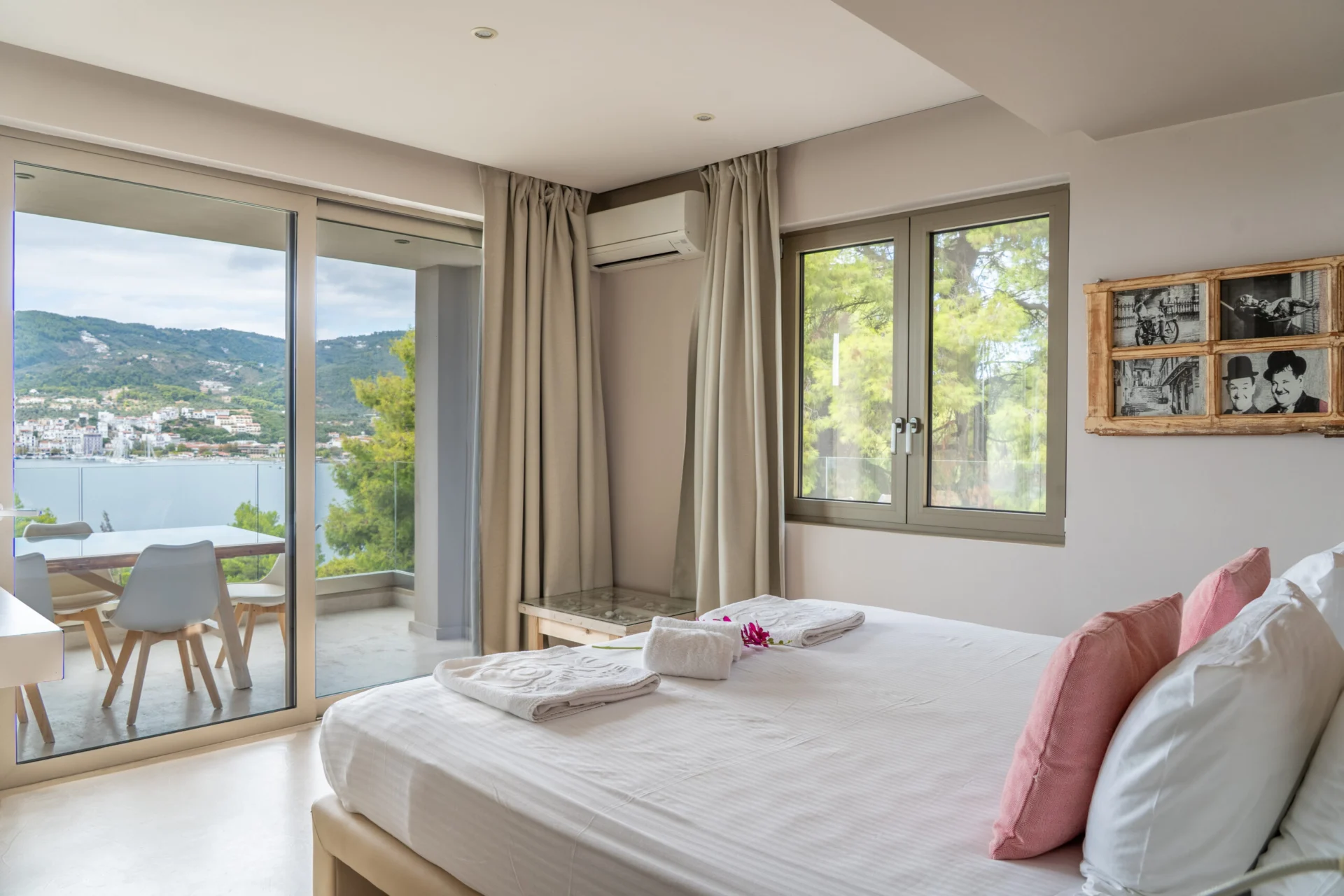 A bedroom looking out across its terrace to the bay in the Stavros Family Suite at CORE Luxury Suites, Skiathos.