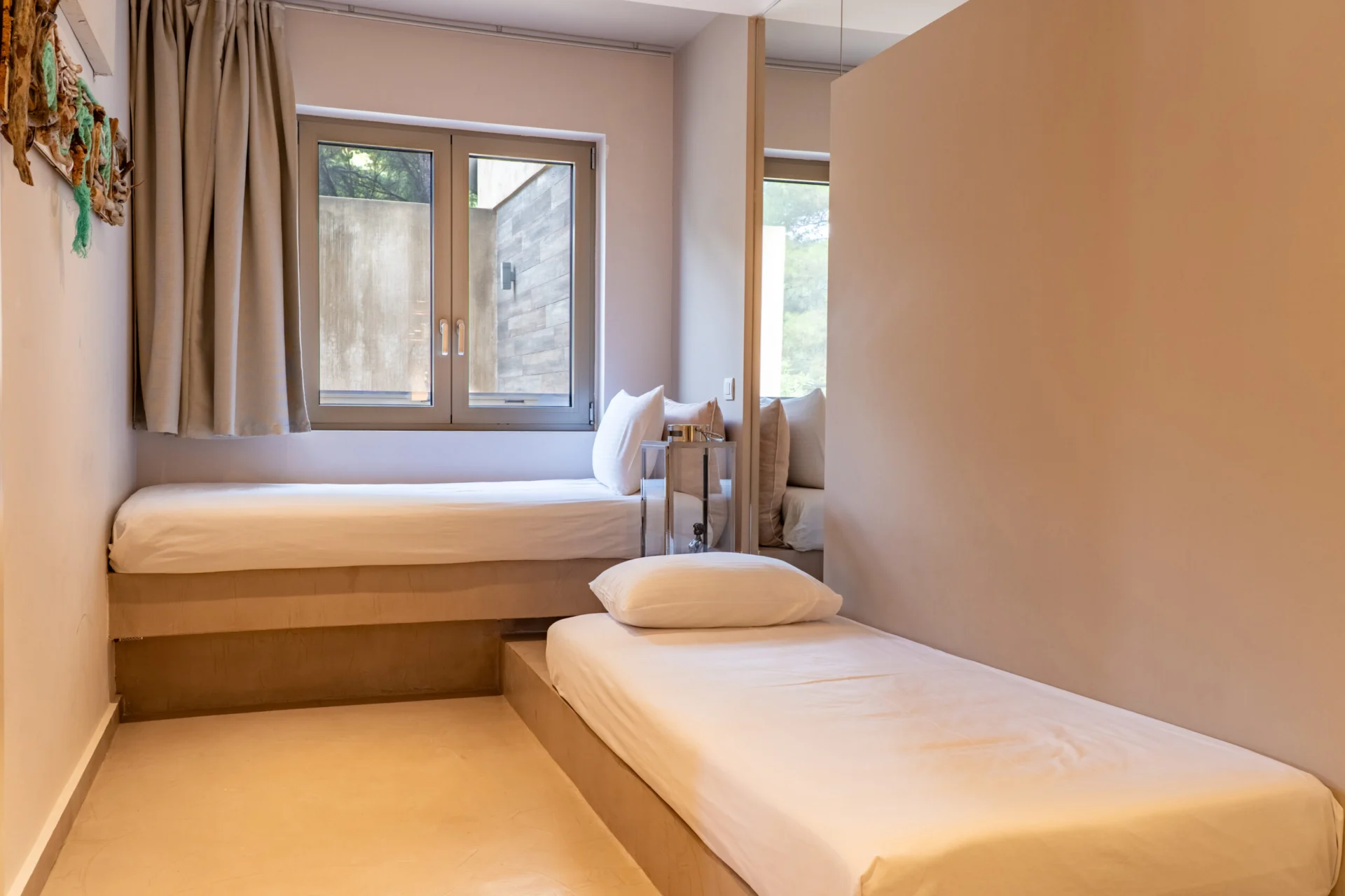 Due letti singoli affiancati sotto la finestra nella Stavros Family Suite di CORE Luxury Suites, Skiathos.
