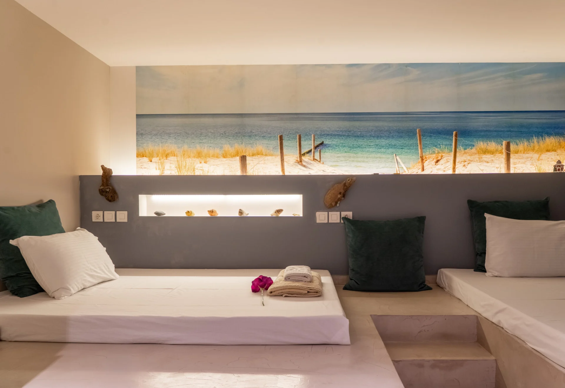 Una camera da letto con un murale dipinto raffigurante la spiaggia e cuscini verdi nella Vassiliki Deluxe Suite di CORE Luxury Suites, Skiathos.