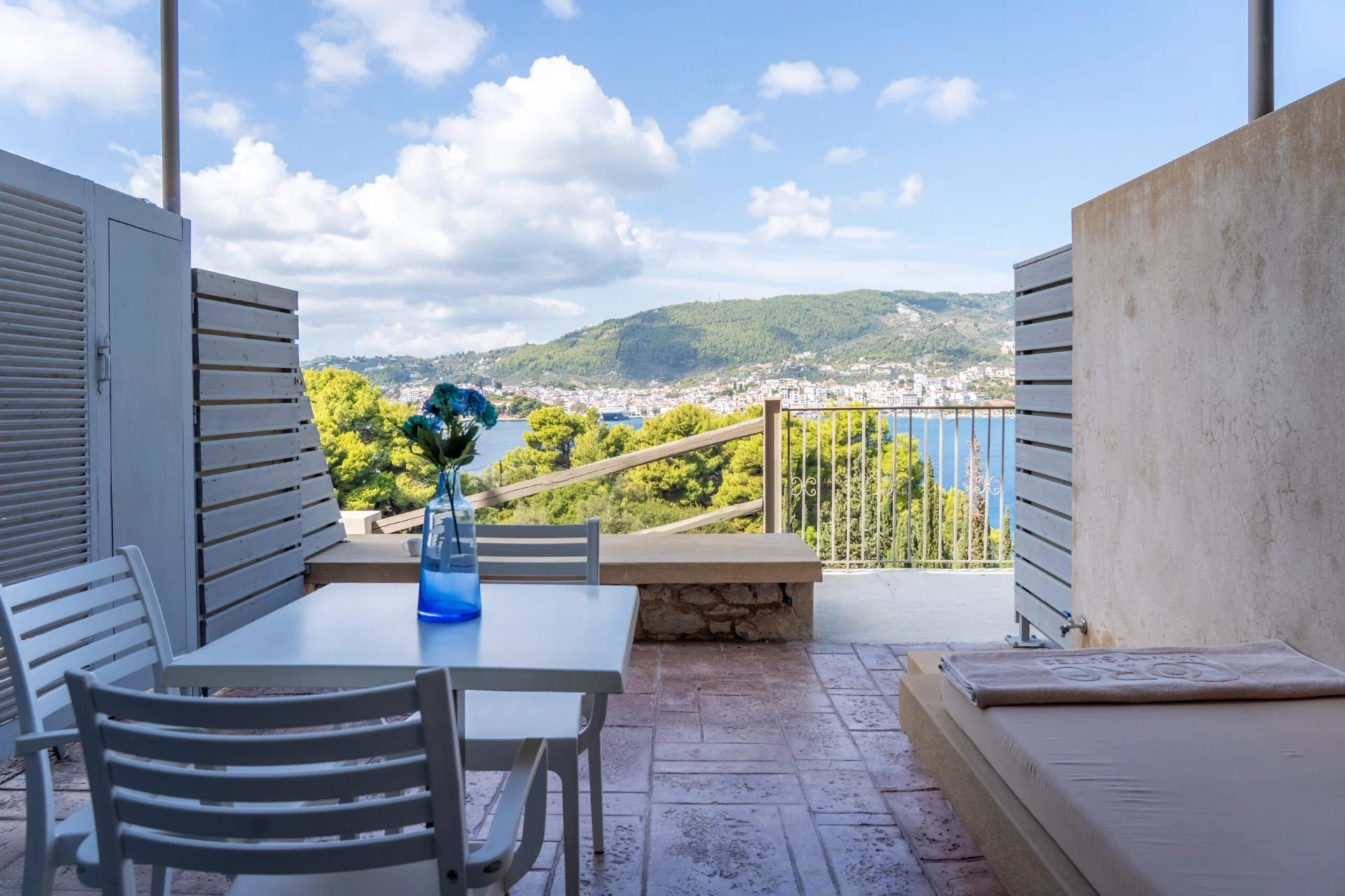 Ein Tisch auf der terrace mit Blick über die Bucht in der Vassiliki Deluxe Suite bei CORE Luxury Suites, Skiathos.