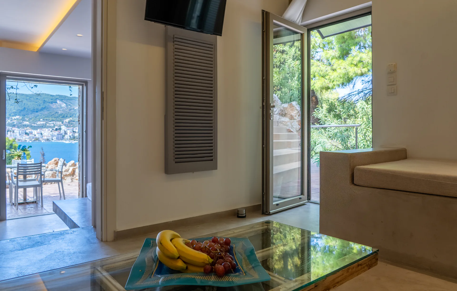 Un soggiorno con porte aperte sulla terrace e sulla baia nella Alessia Family Suite di CORE Luxury Suites, Skiathos.