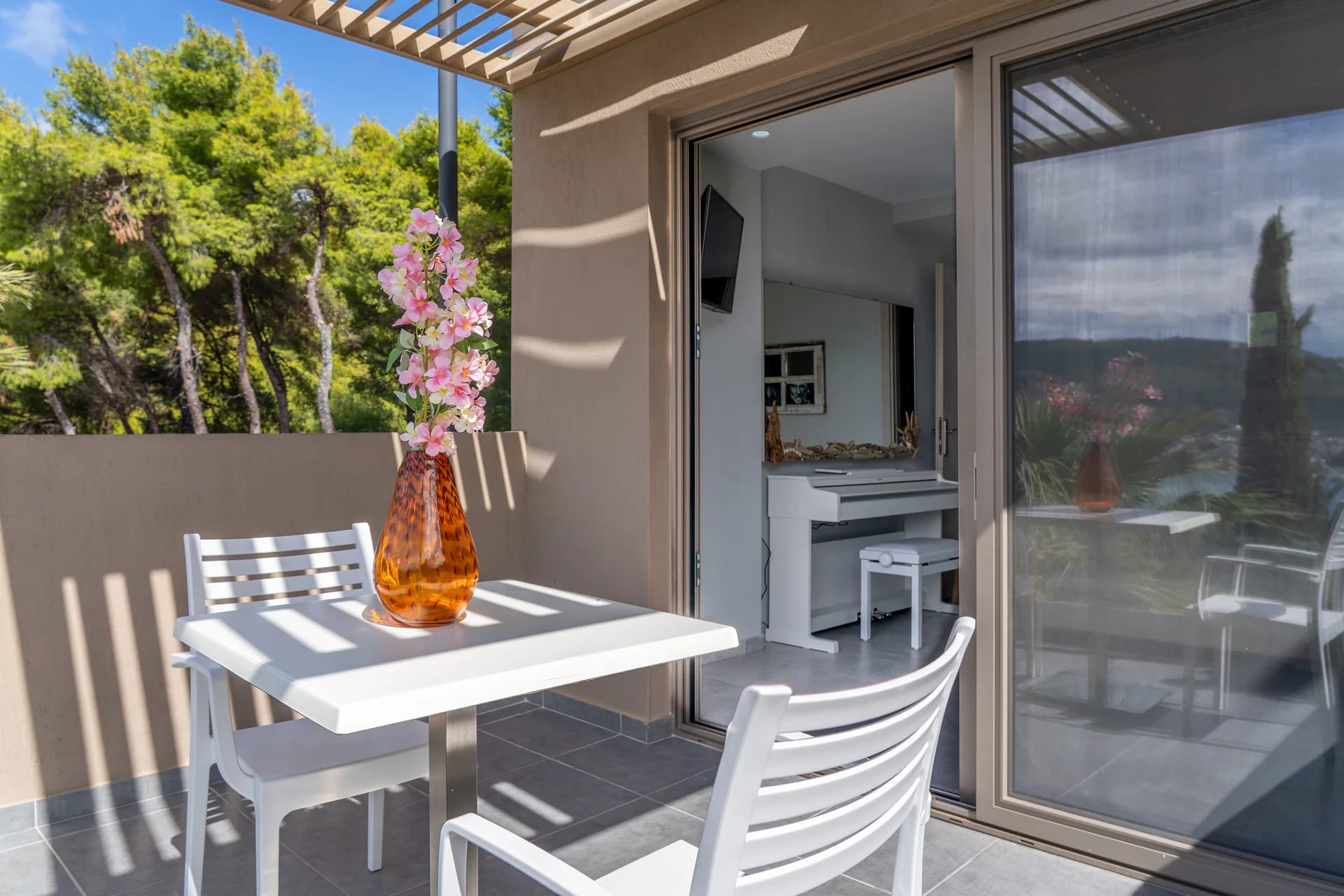 Un tavolo sulla terrace sotto il pergolato, accanto alla porta scorrevole, nella Alex 2 Deluxe Suite di CORE Luxury Suites, Skiathos.