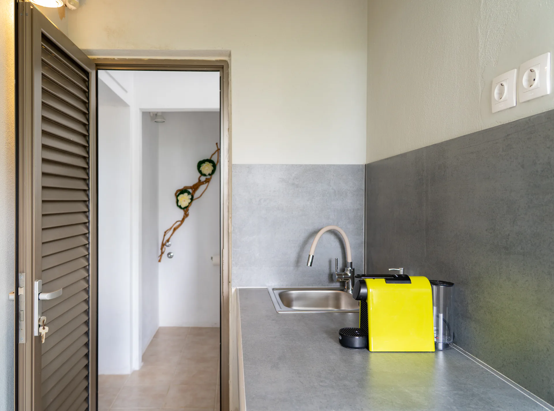Il piano di lavoro dell’angolo cottura con una macchina da caffè gialla nella Alex 3 Superior Suite di CORE Luxury Suites, Skiathos.