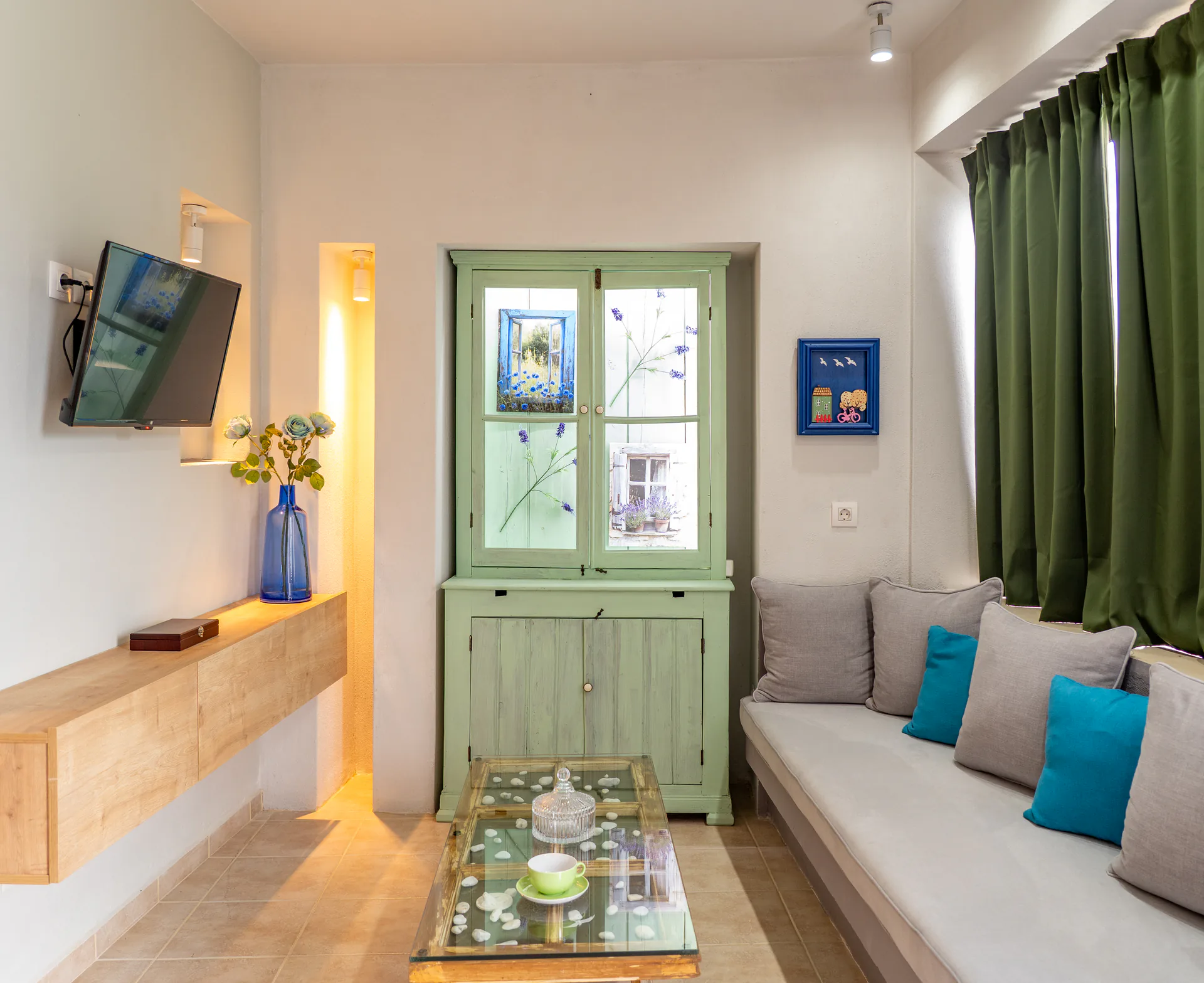 Un soggiorno con cassettiera dipinta di verde e panca integrata nella Alex 3 Superior Suite di CORE Luxury Suites, Skiathos.