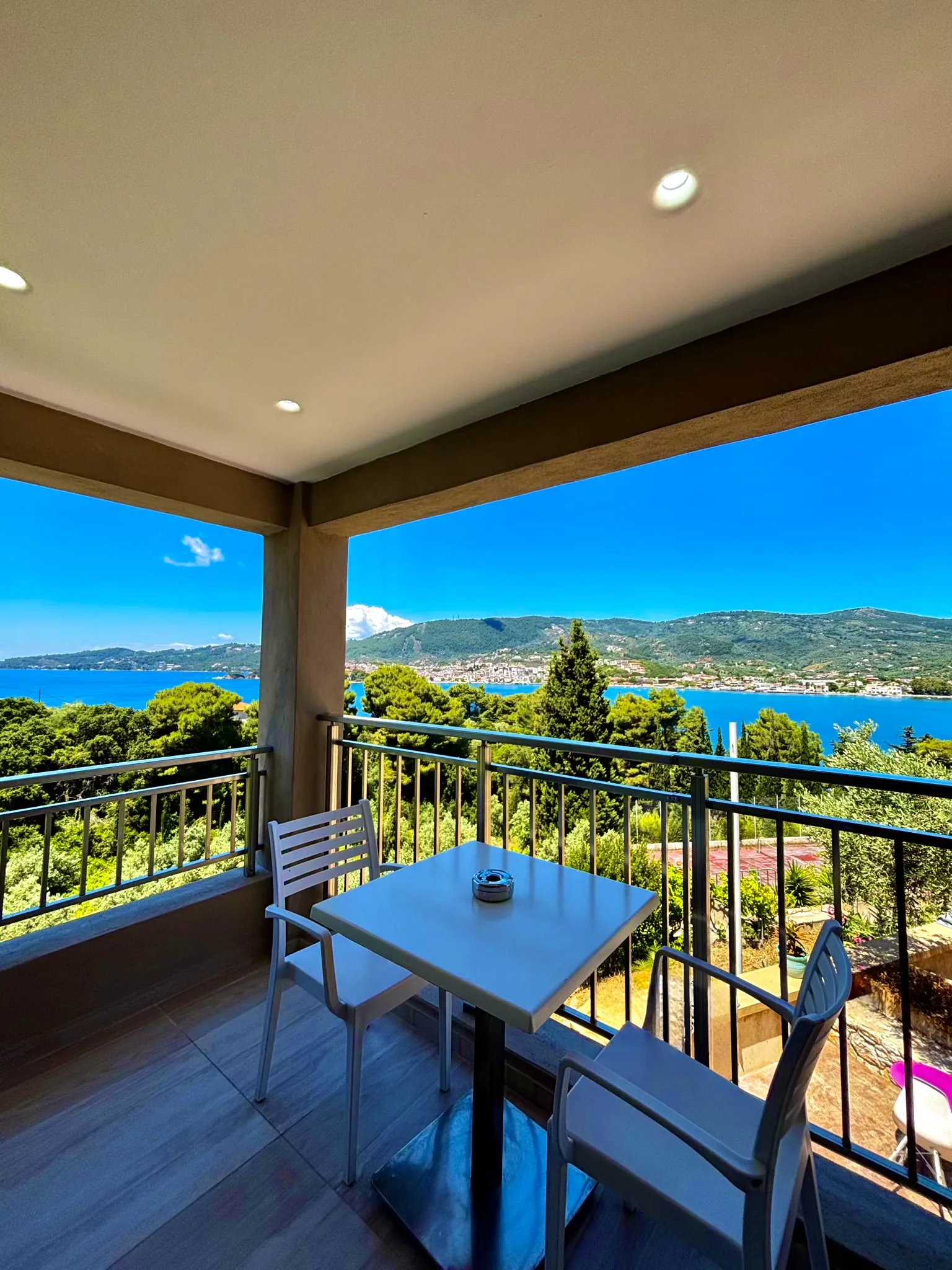 Ein Tisch und zwei Stühle auf der terrace über der Bucht in der Cassy Deluxe Suite bei CORE Luxury Suites, Skiathos.