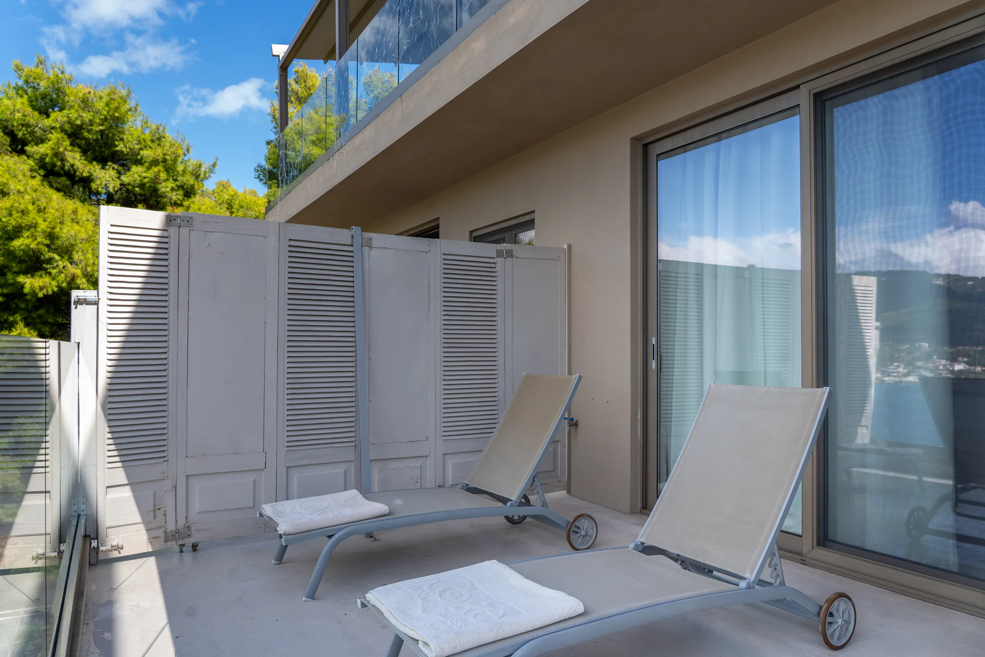 Zwei Sonnenliegen hinter einem Lamellen-Sichtschutz in der Daniel Signature Suite bei CORE Luxury Suites, Skiathos.