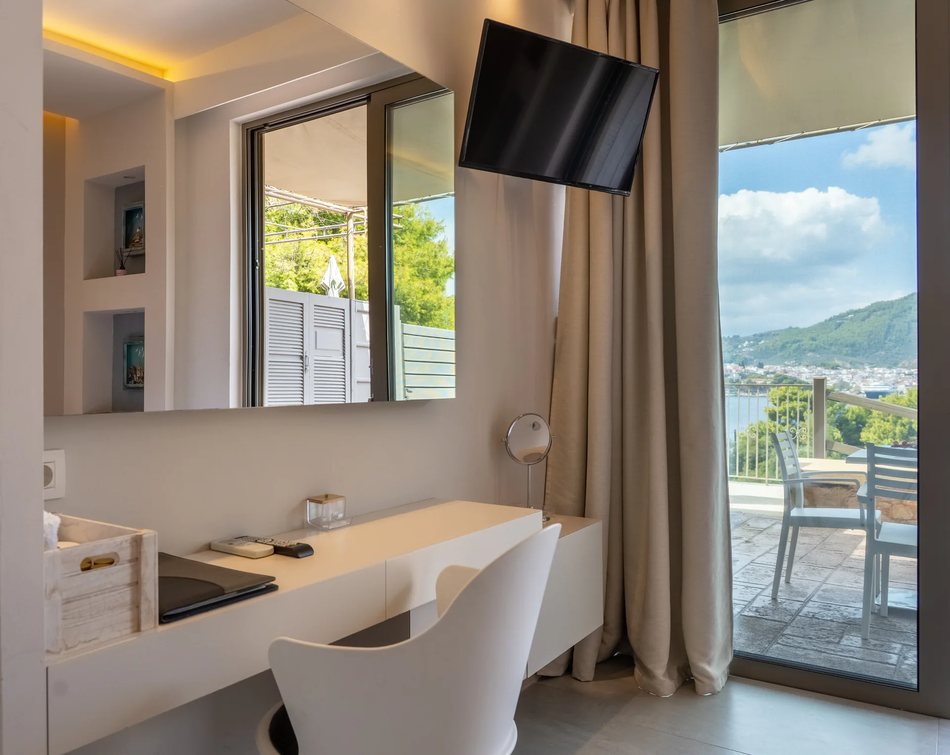 A white dressing table beside a window onto the terrace in the Demi Classic Suite at CORE Luxury Suites, Skiathos.
