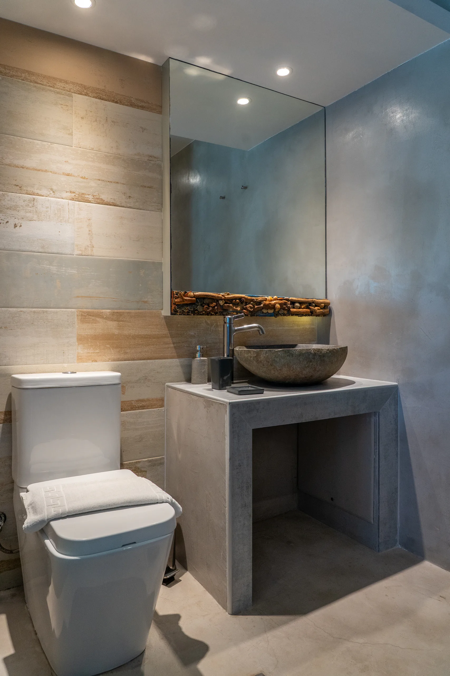 Un lavabo in pietra su una base di cemento, sotto una mensola in legno portato dal mare, nella Georgia Superior Suite di CORE Luxury Suites, Skiathos.
