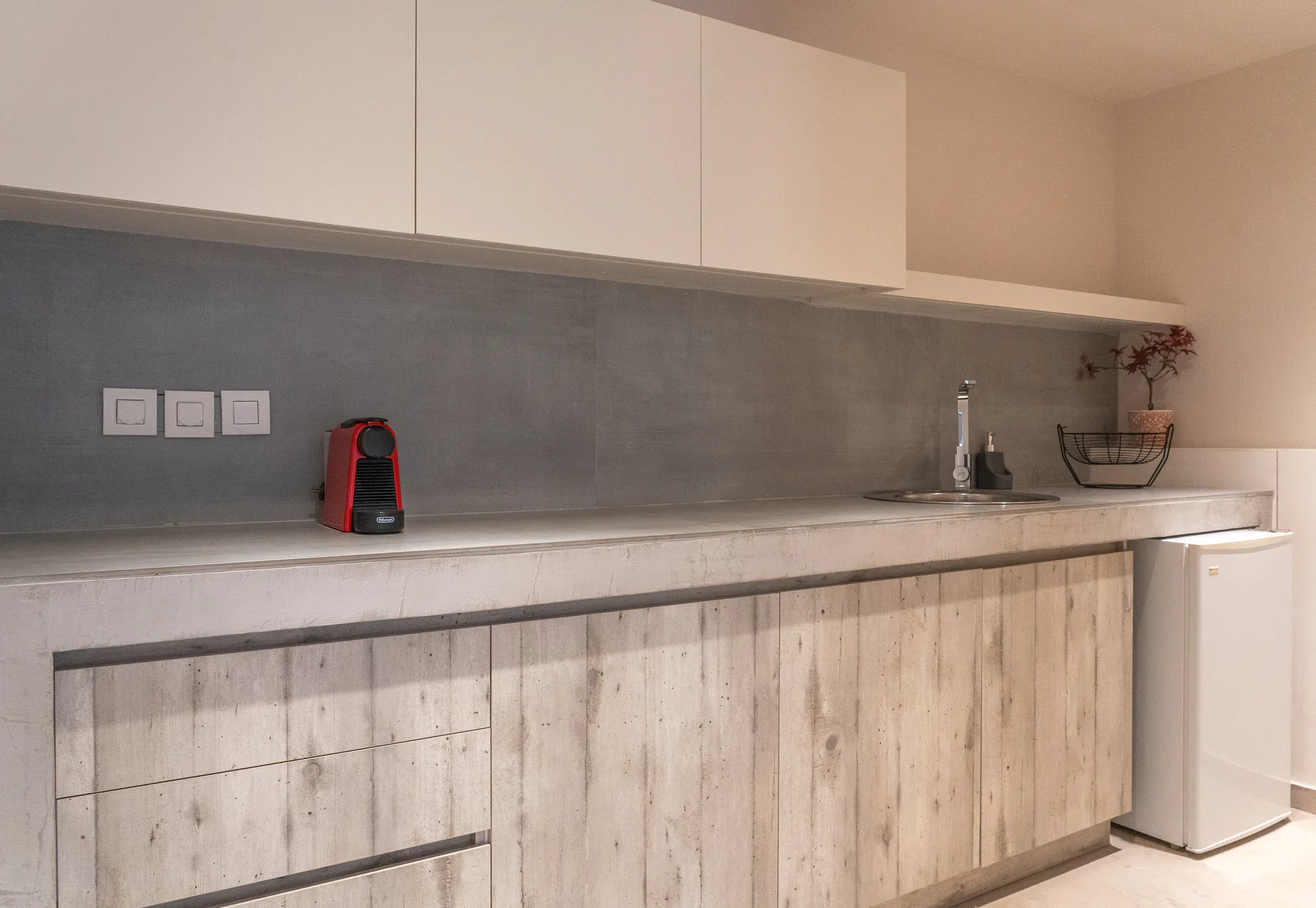 A kitchenette in concrete with reclaimed timber doors in the Kassandra Signature Suite at CORE Luxury Suites, Skiathos.