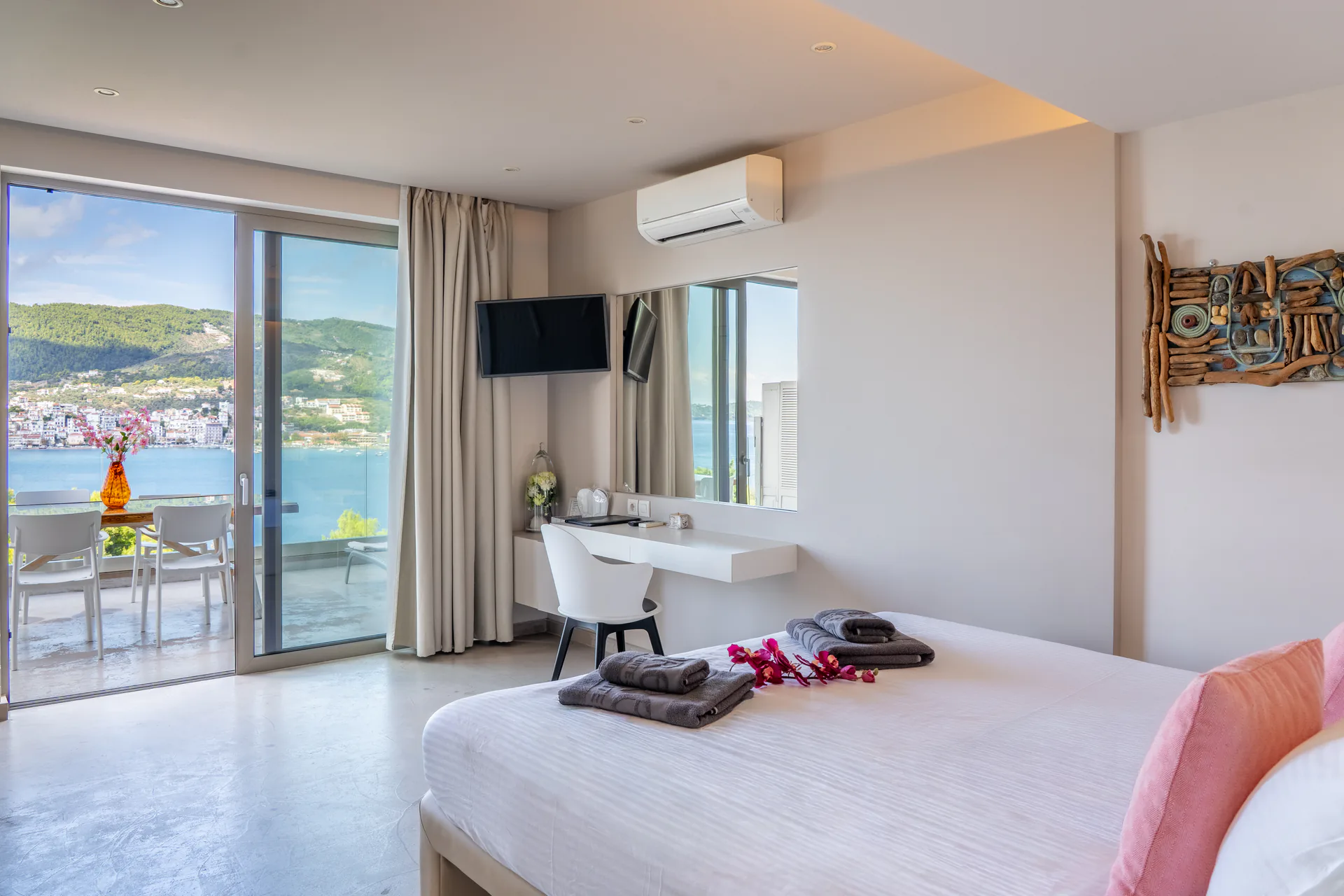 A bedroom with sliding doors open to the terrace and the bay in the Patrick Family Suite at CORE Luxury Suites, Skiathos.