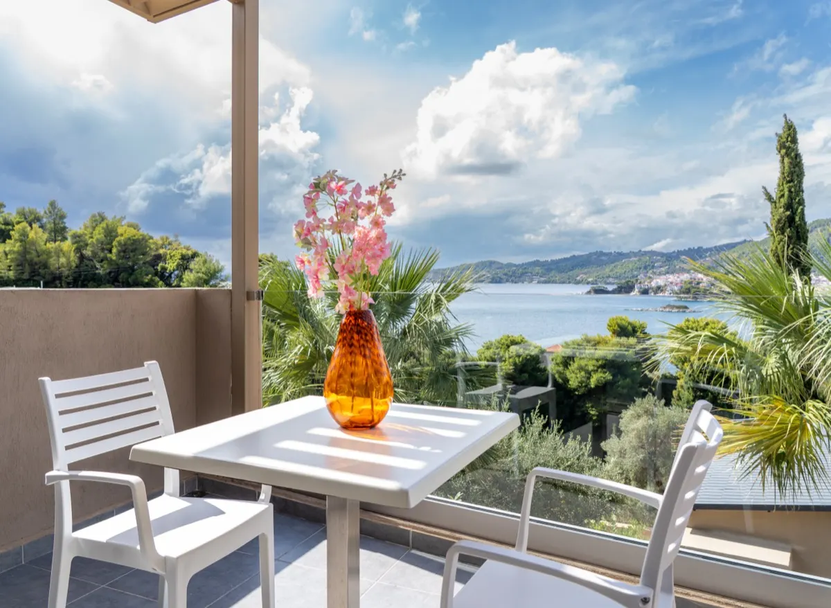 An orange vase on a terrace table with the bay beyond